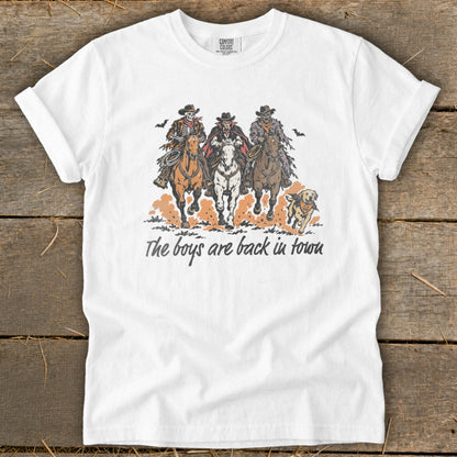 T-shirt graphic with three spooky cowboys on horses and a dog, text reads "The boys are back in town."