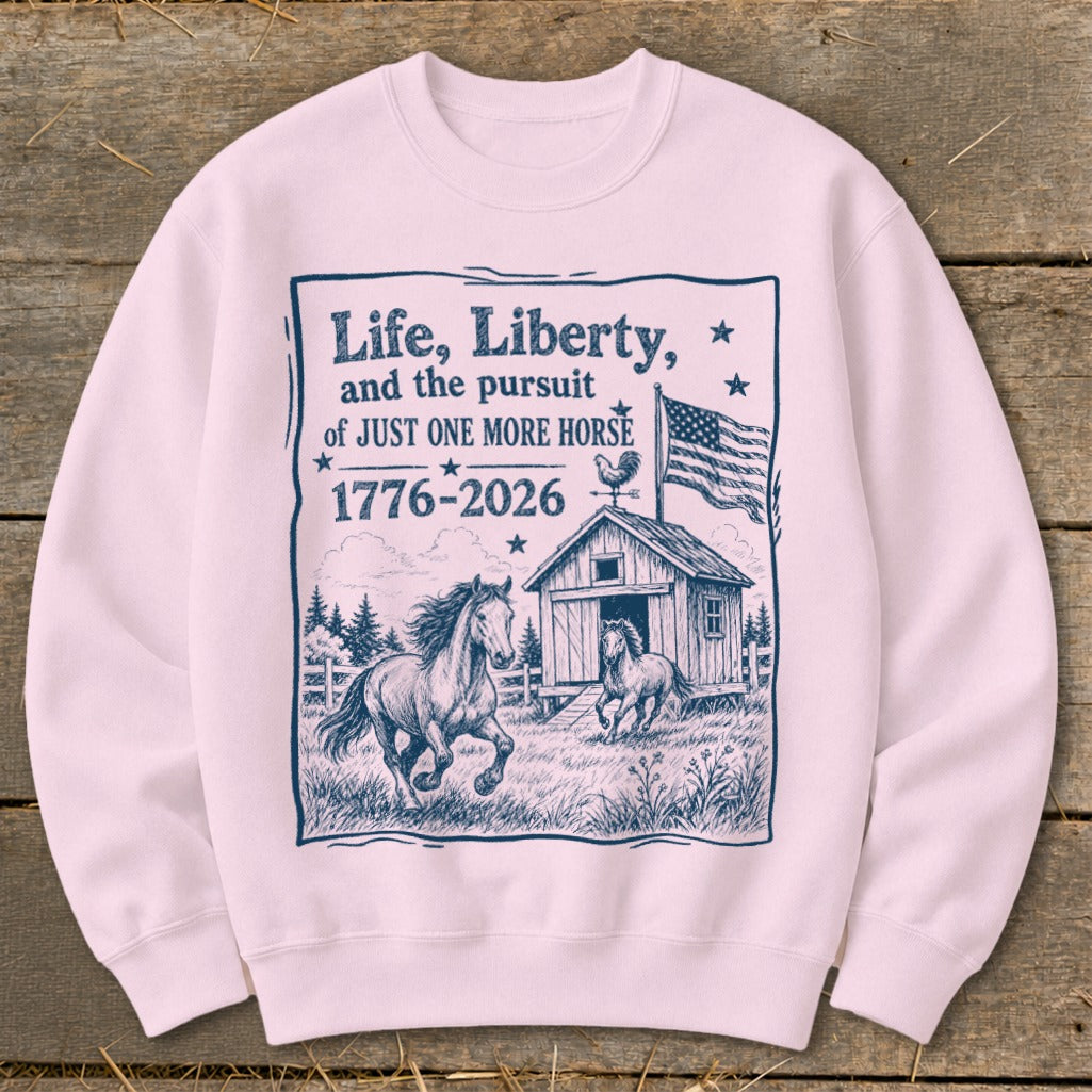 Light pink sweatshirt with a barn, horses, American flag, and text about "just one more horse."