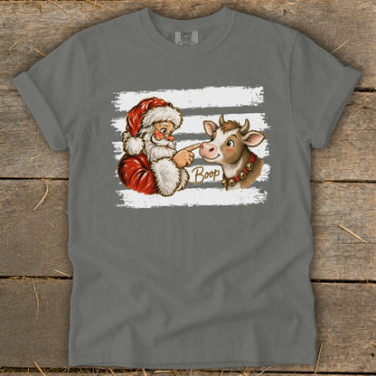 Santa booping a cow's nose with the word "Boop" on a t-shirt.