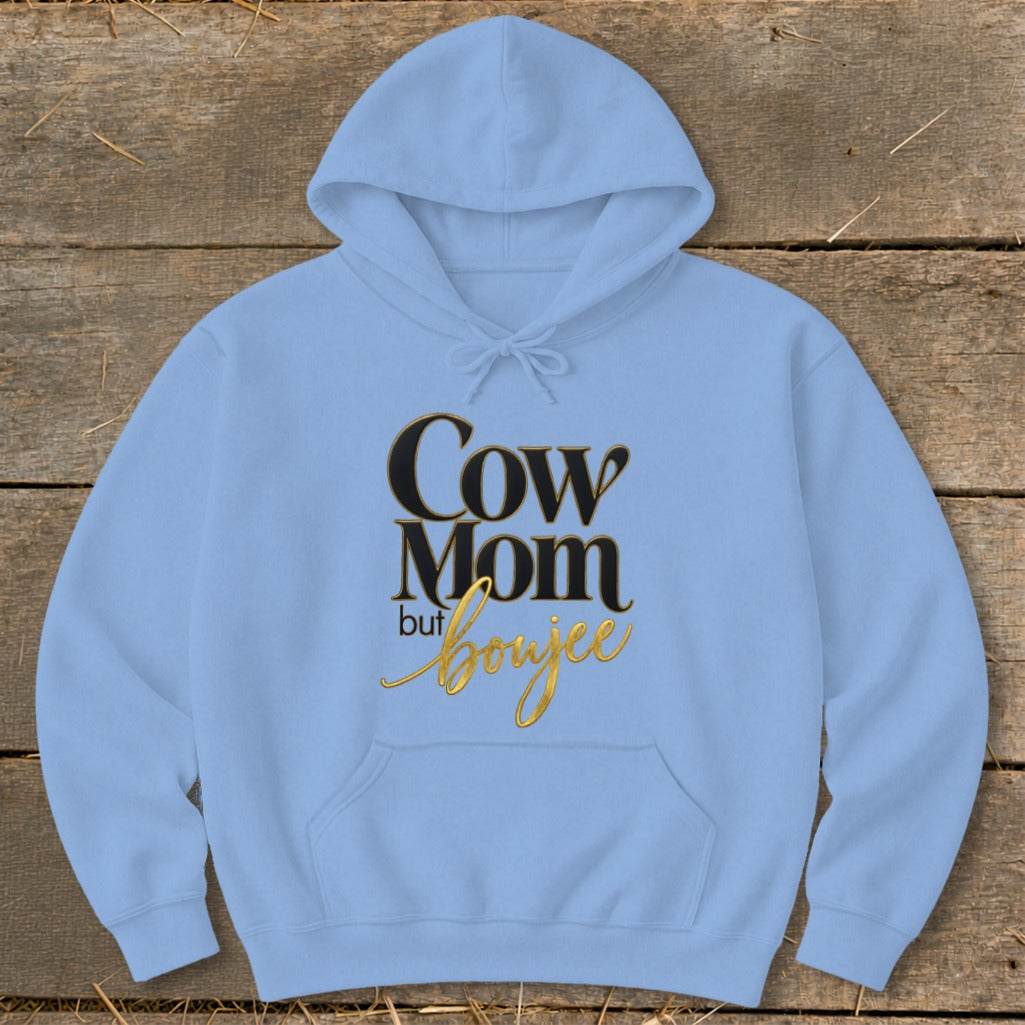 Light blue hoodie with "Cow Mom but boujee" text in black and gold.