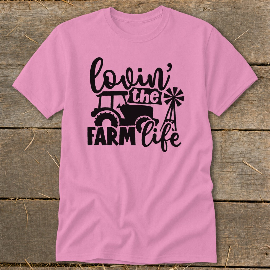 Pink t-shirt with black graphic of tractor, windmill, and text "lovin' the FARM life".
