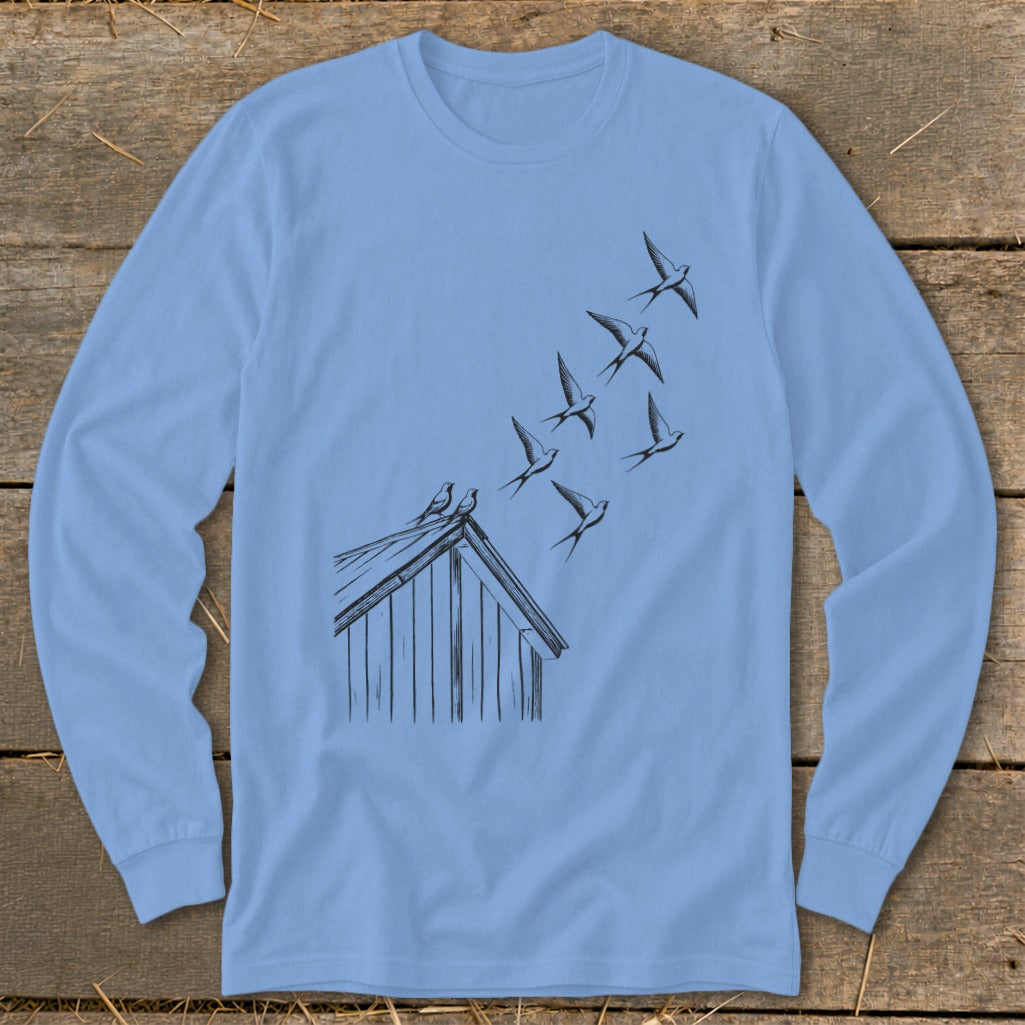 Light blue long-sleeve t-shirt featuring a black line drawing of swallows flying from a barn roof.