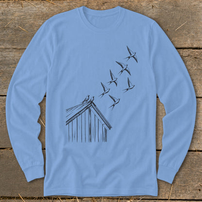 Light blue long-sleeve t-shirt featuring a black line drawing of swallows flying from a barn roof.