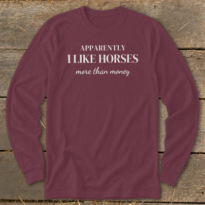 Maroon long sleeve shirt with white text that reads "Apparently I like horses more than money".