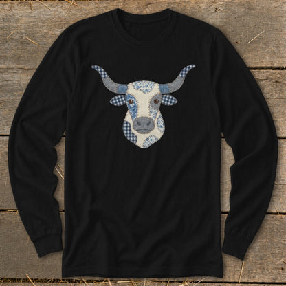 Long-sleeve black shirt with a cow face appliqué made of blue and white fabric patterns.