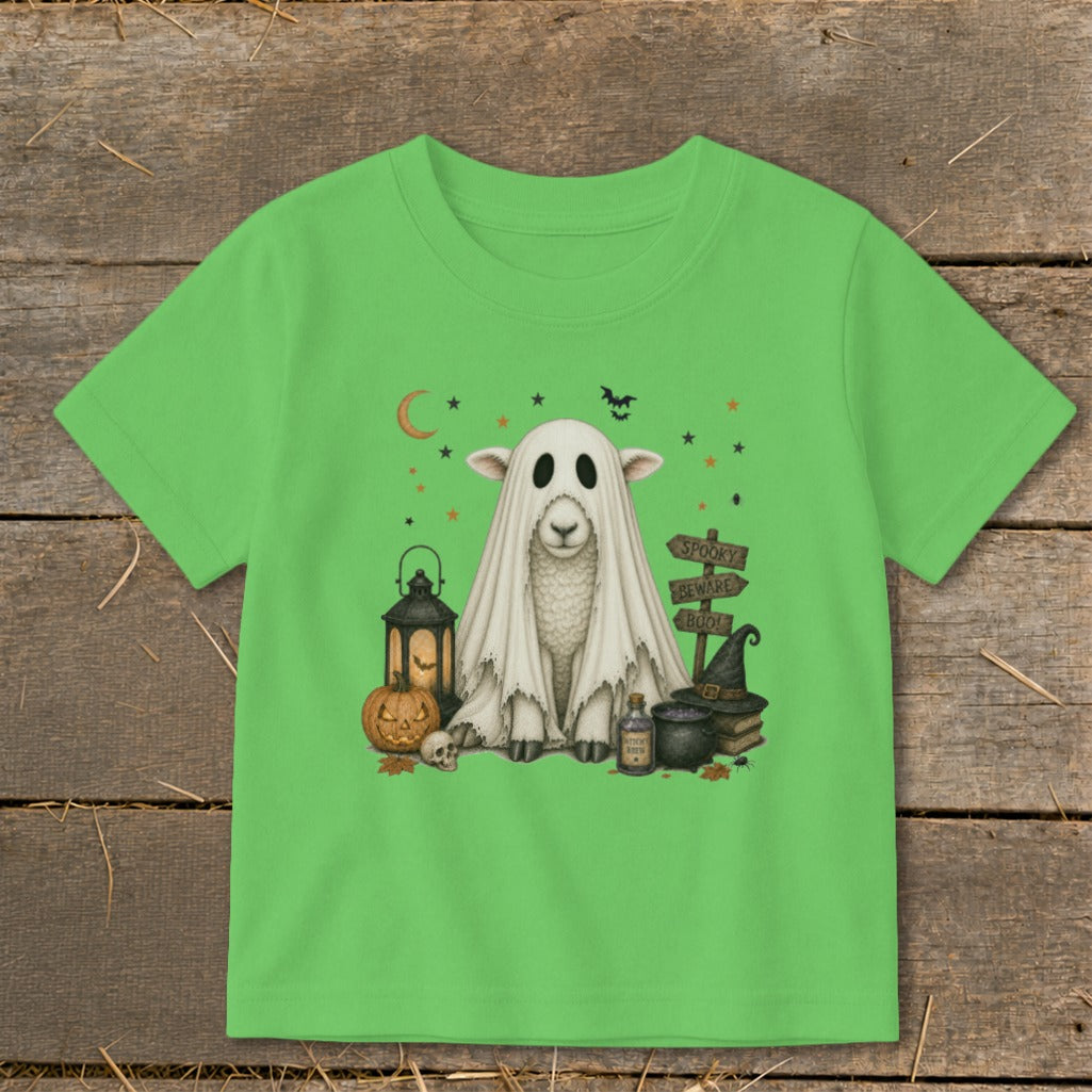 Sheep in ghost costume surrounded by Halloween elements including pumpkin and lantern.