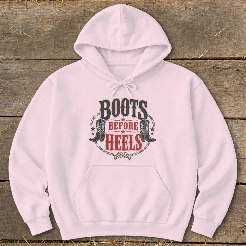 Pink hoodie with "Boots Before Heels" graphic featuring cowboy boots and rope detail.