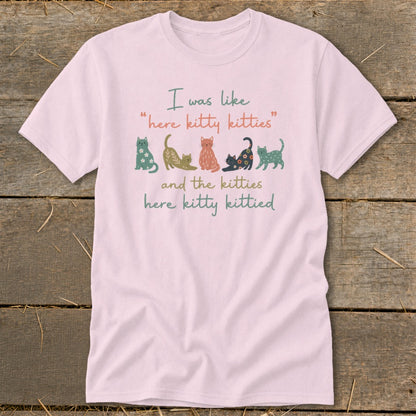 Pink t-shirt with cats and text "I was like 'here kitty kitties' and the kitties here kitty kittied".