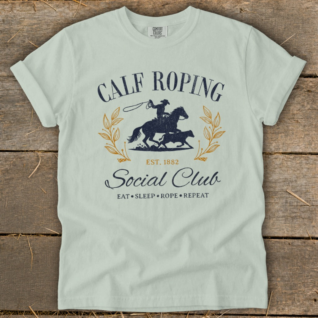 Calf Roping Social Club t-shirt with cowboy, calf, and laurel wreath graphic.