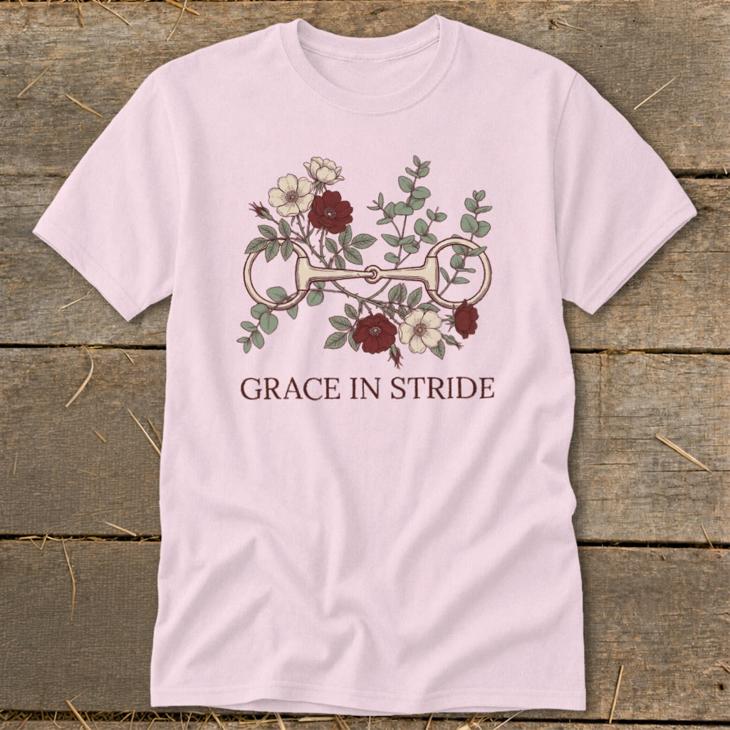 Pink t-shirt with horse bit and floral design, reads "GRACE IN STRIDE."