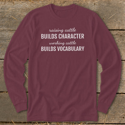 Maroon long-sleeve shirt with text "raising cattle BUILDS CHARACTER working cattle BUILDS VOCABULARY".
