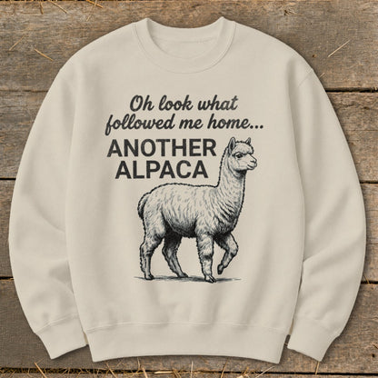 Cream sweatshirt with text "Oh look what followed me home... ANOTHER ALPACA" and alpaca graphic.