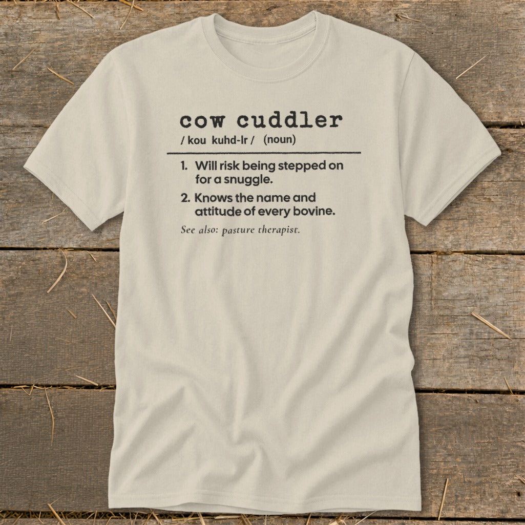 Light beige t-shirt with "cow cuddler" definition printed on it.
