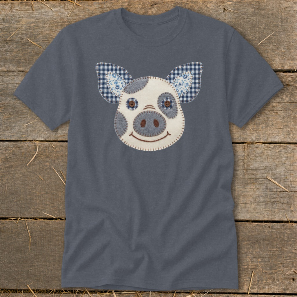 Grey t-shirt with a fabric applique of a pig's face and checkered ears.