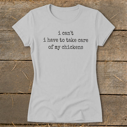 Light gray t-shirt with black text that says "i can't i have to take care of my chickens".