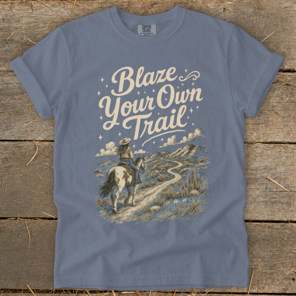 Blue t-shirt with "Blaze Your Own Trail" text and a woman riding a horse on a desert path.