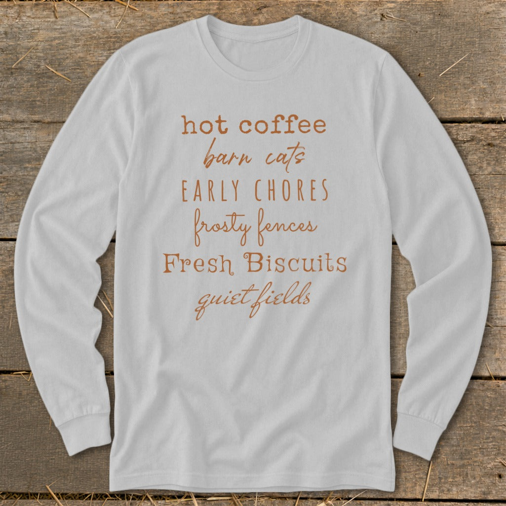 White long sleeve shirt with text: hot coffee, barn cats, early chores, frosty fences, Fresh Biscuits, quiet fields.