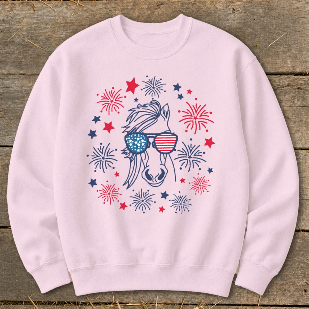 Pink sweatshirt with a horse wearing American flag sunglasses surrounded by fireworks and stars.