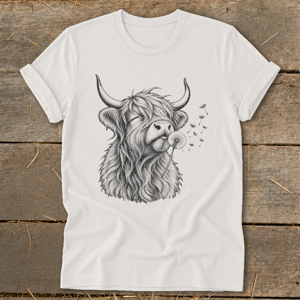Highland cow with closed eyes blowing dandelion seeds on a white t-shirt.