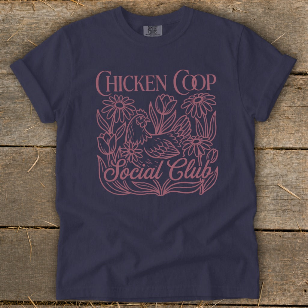 Navy t-shirt with pink "Chicken Coop Social Club" graphic featuring a chicken and flowers.