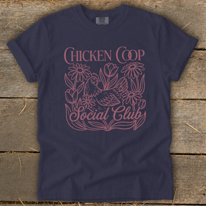 Navy t-shirt with pink "Chicken Coop Social Club" graphic featuring a chicken and flowers.