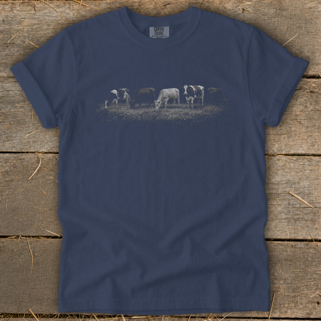 Lineup of cows grazing in a field on a navy blue t-shirt.
