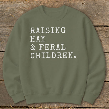 Olive green sweatshirt with white text "RAISING HAY & FERAL CHILDREN."