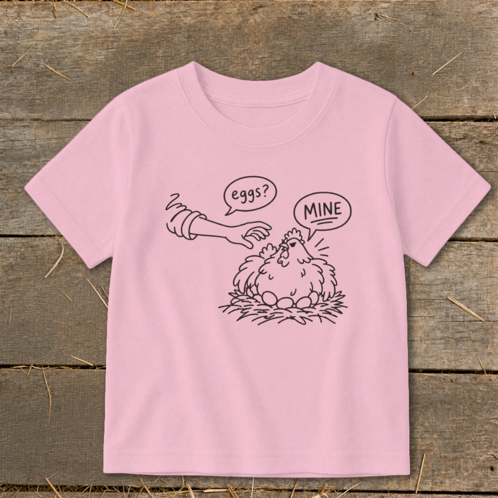 Pink t-shirt with cartoon chicken guarding eggs, speech bubbles say "eggs?" and "MINE".