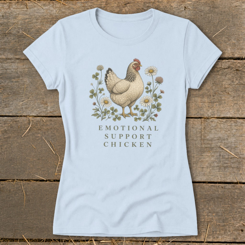 Light blue t-shirt with a chicken, clover, and flowers graphic and text "Emotional Support Chicken."
