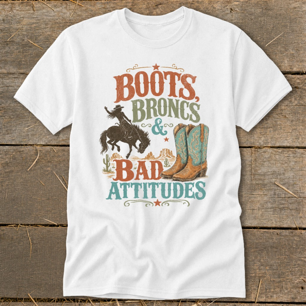 T-shirt graphic with text "Boots, Broncs & Bad Attitudes", a bucking bronco rider, and cowboy boots.