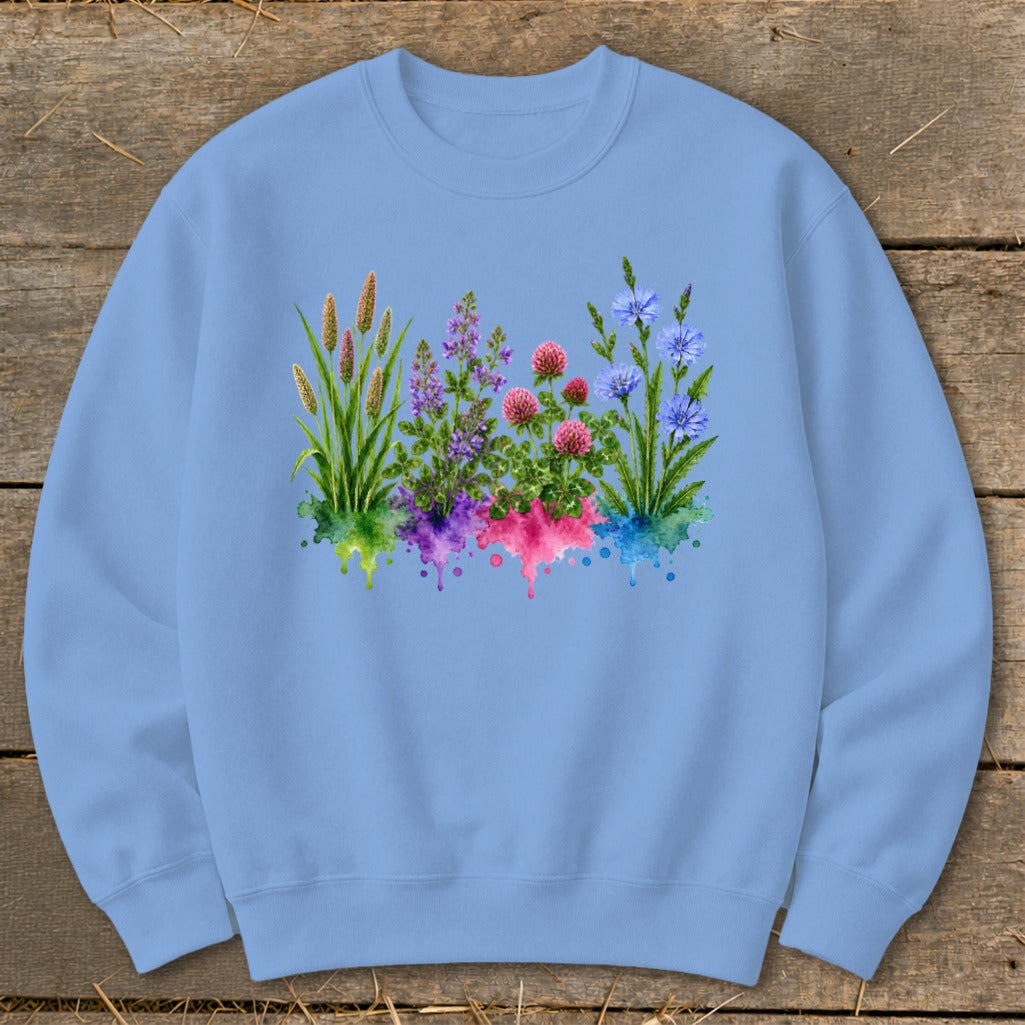 Light blue crewneck sweatshirt featuring a colorful watercolor print of wild flowers and grasses on the chest.