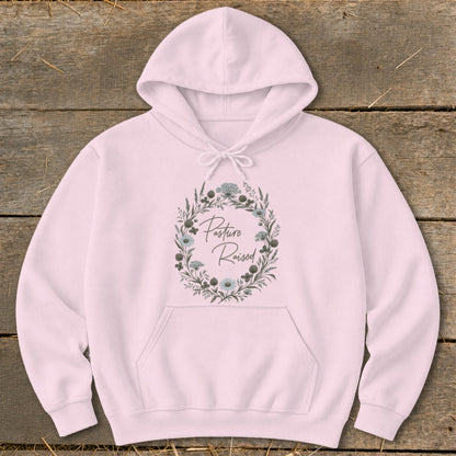 Pink hoodie with floral wreath graphic and text "Pasture Raised".