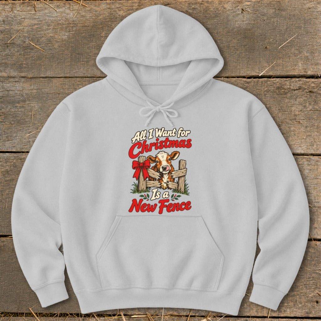 Light grey hoodie with a graphic of a cow peeking over a fence with text "All I Want for Christmas Is a New Fence".