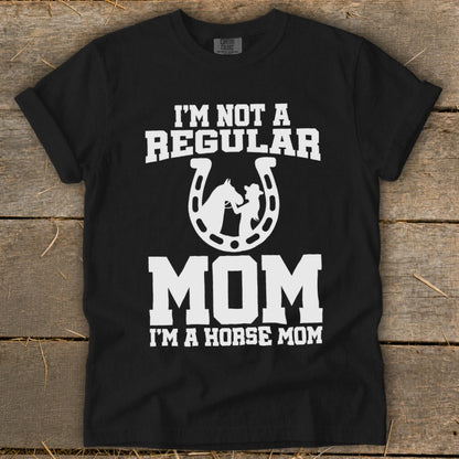 Black t-shirt with white text "I'M NOT A REGULAR MOM I'M A HORSE MOM" and horseshoe graphic.