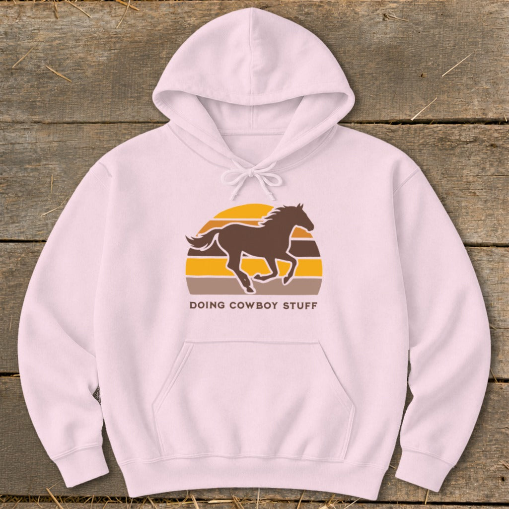 Pink hoodie with a running horse graphic and "DOING COWBOY STUFF" text.
