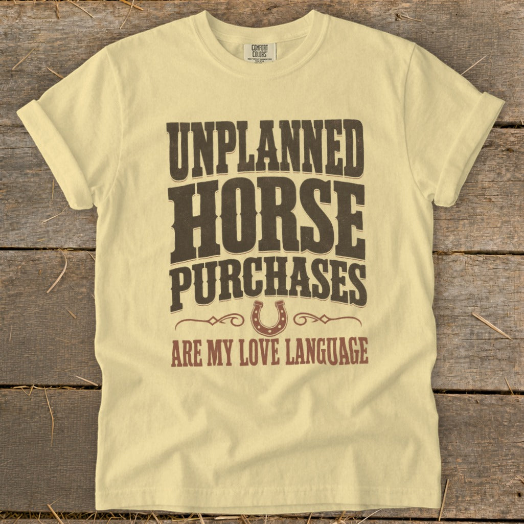 Light yellow t-shirt with "Unplanned Horse Purchases Are My Love Language" text and horseshoe graphic.
