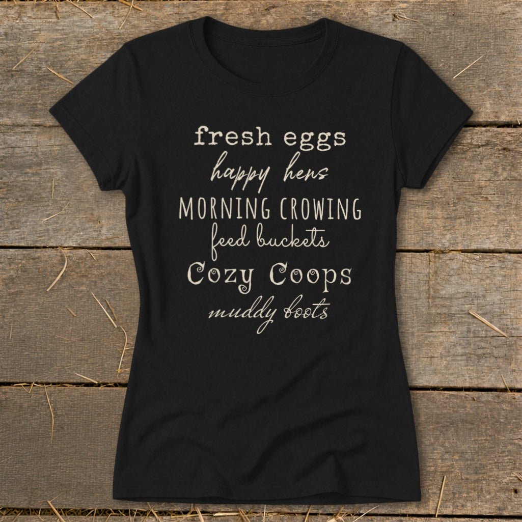 Black t-shirt with text: "fresh eggs happy hens MORNING CROWING feed buckets Cozy Coops muddy boots"