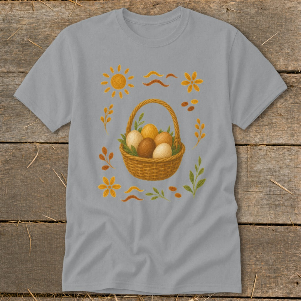 Gray t-shirt with a woven basket filled with brown and cream eggs, surrounded by floral and sun motifs.
