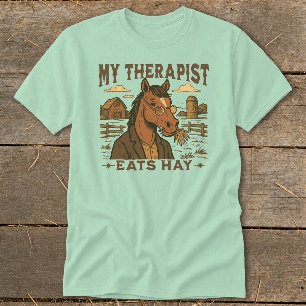 Light teal t-shirt with "MY THERAPIST EATS HAY" and horse graphic.