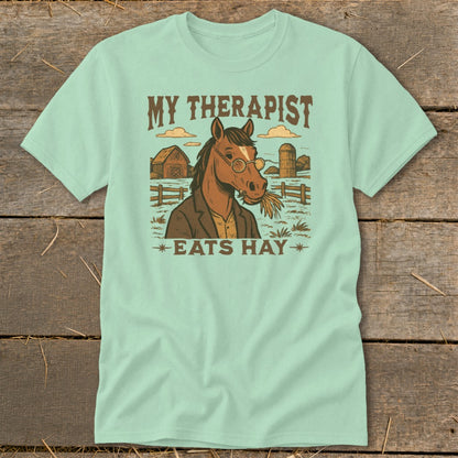 Light teal t-shirt with "MY THERAPIST EATS HAY" and horse graphic.