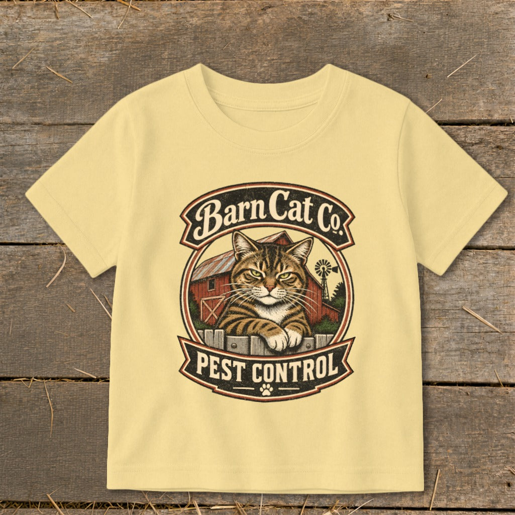 A light yellow t-shirt features a vintage graphic of a tabby cat and a barn with the text Barn Cat Co. Pest Control.