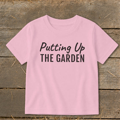 Pink t-shirt with black text "Putting Up THE GARDEN"