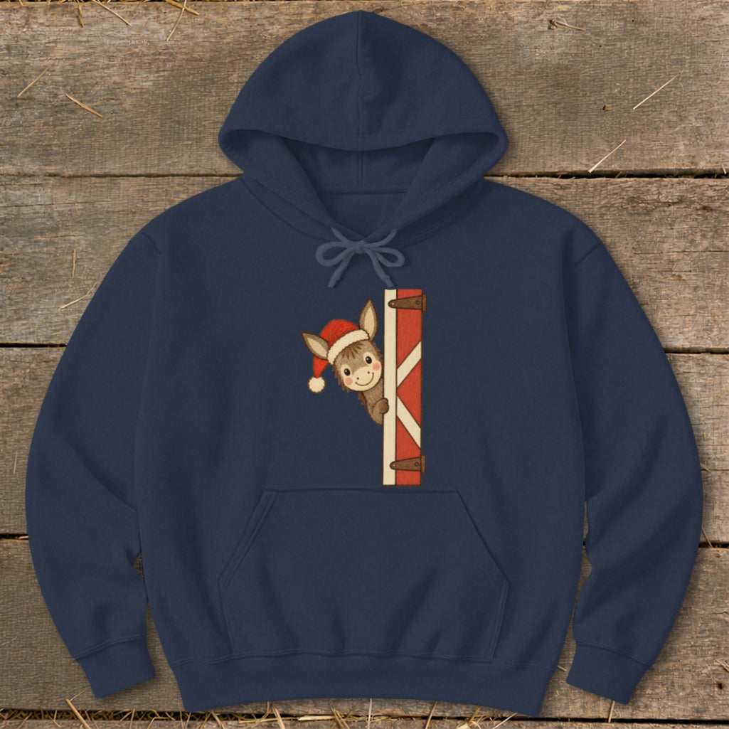 Navy hoodie with a peeking donkey wearing a Santa hat next to a red and white striped gate.
