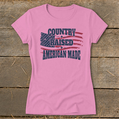 Pink t-shirt with distressed American flag graphic and text "COUNTRY RAISED AMERICAN MADE".