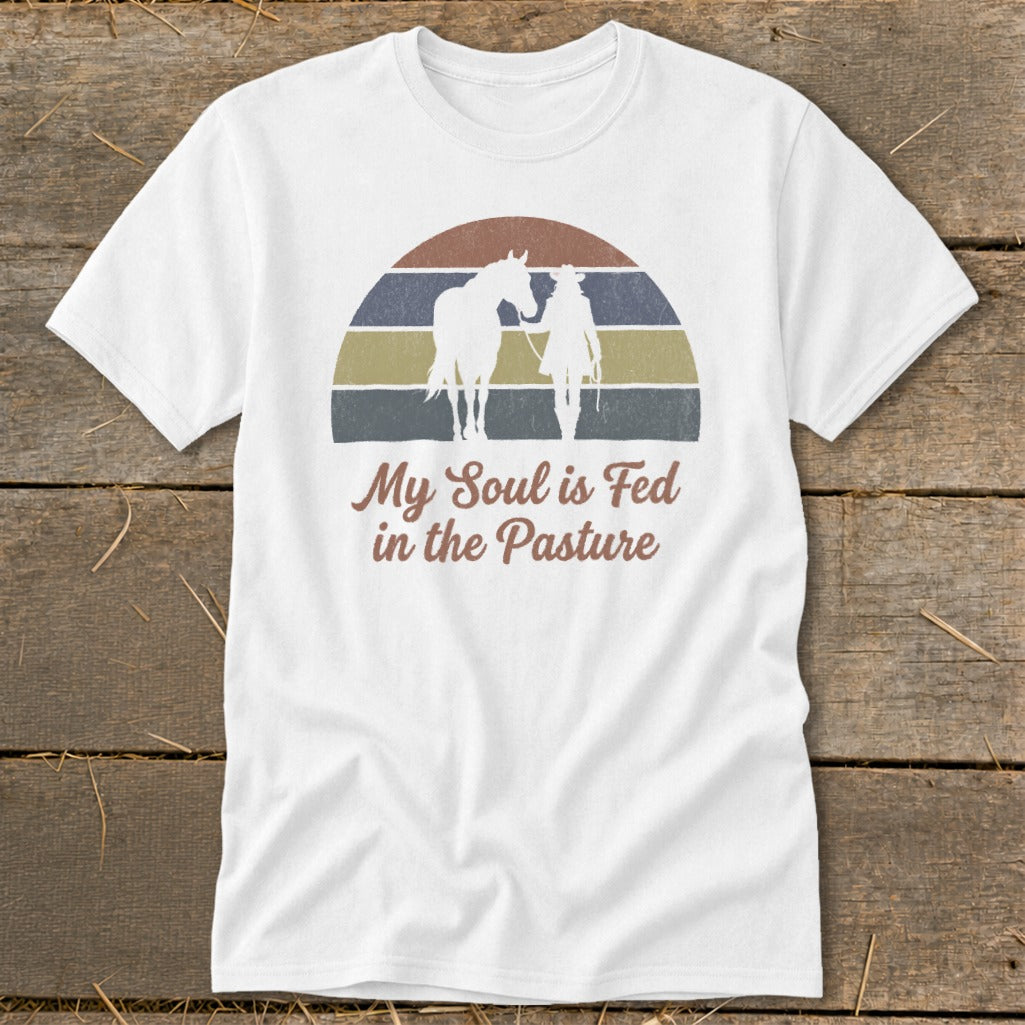 White t-shirt with retro sunset graphic and text "My Soul is Fed in the Pasture."