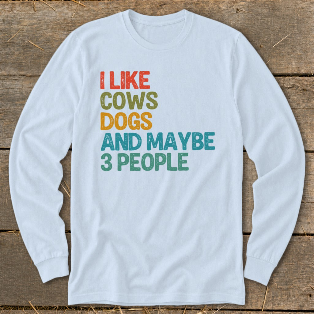 White long sleeve shirt with text "I LIKE COWS DOGS AND MAYBE 3 PEOPLE"