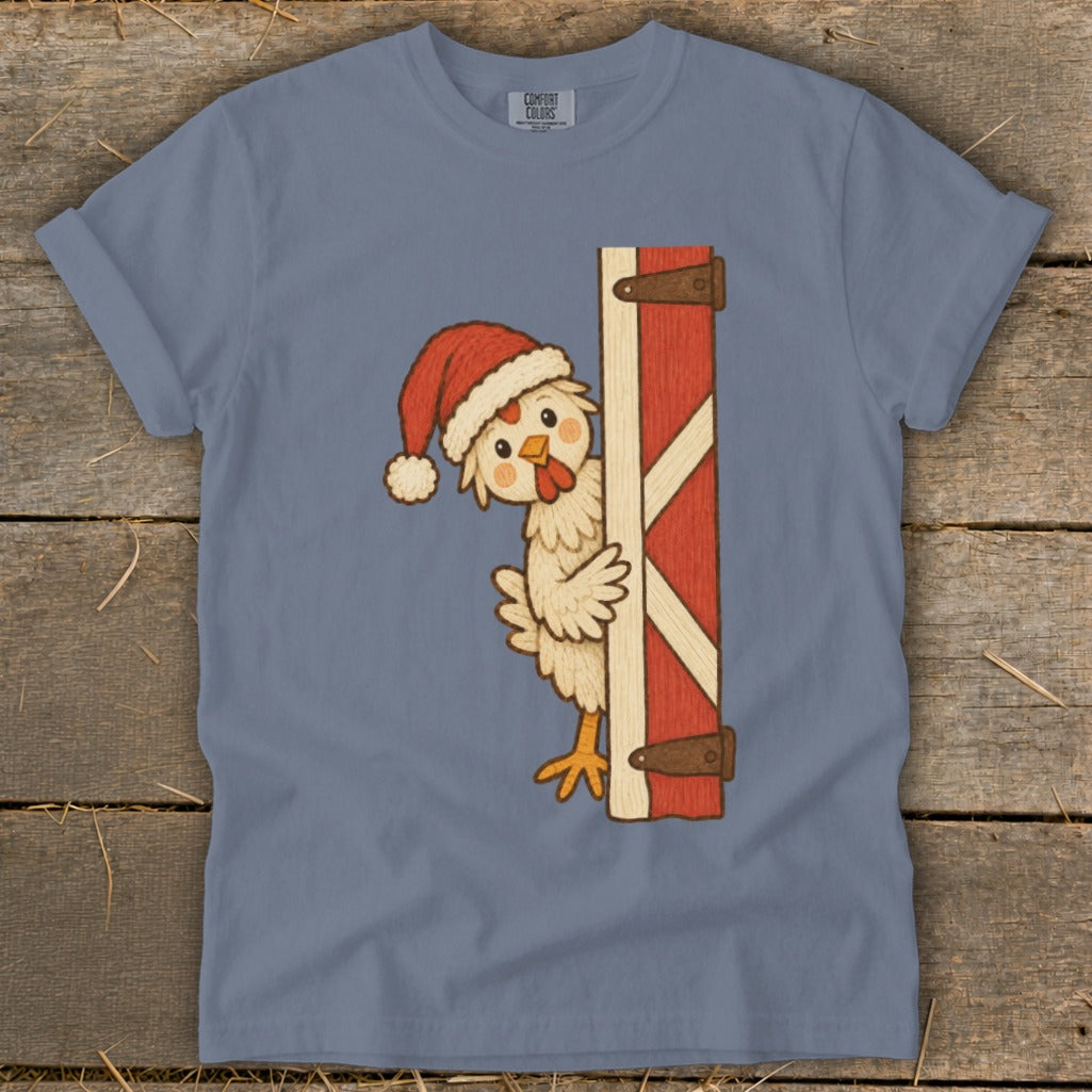 Chicken wearing a Santa hat peeks around a barn door.