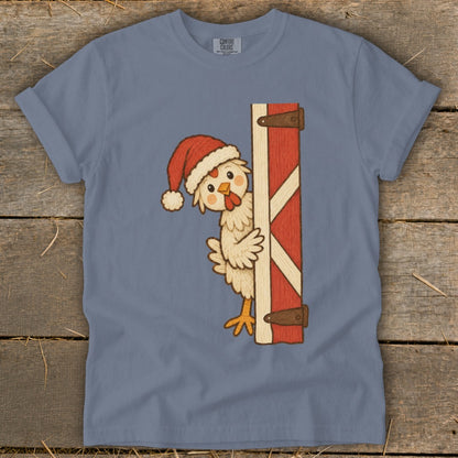 Chicken wearing a Santa hat peeks around a barn door.