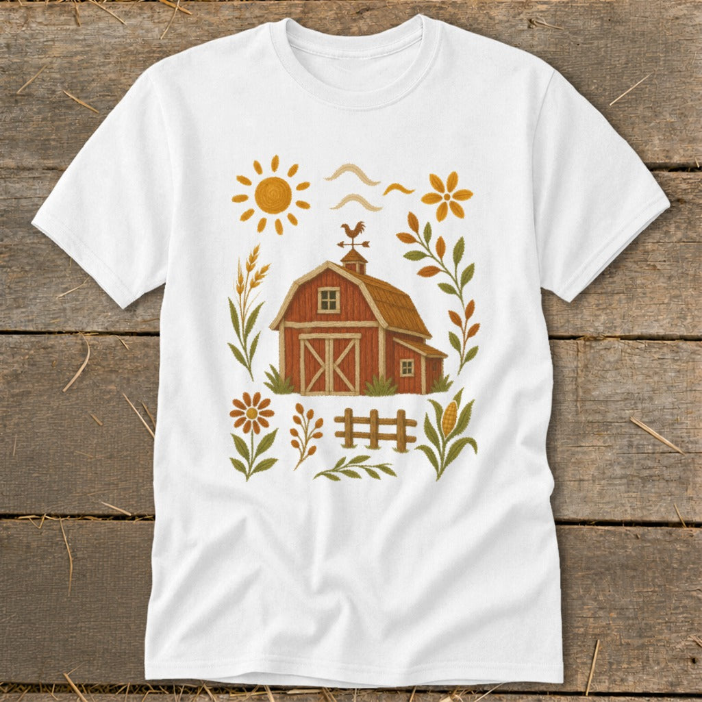 White t-shirt with a rustic barn, sun, flowers, and corn design.