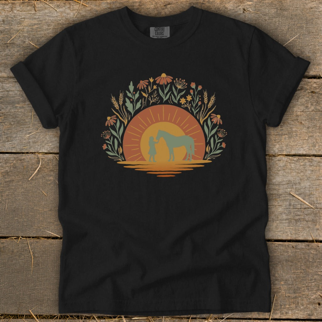 Silhouetted girl and horse at sunset surrounded by wildflowers and wheat.